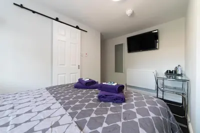 a bedroom with a bed and a tv on the wall at The Norna in Cambridge