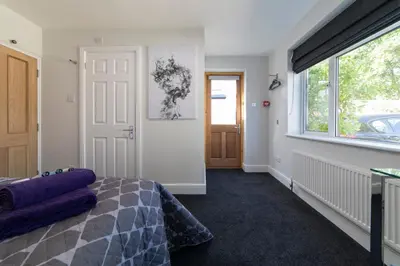 a bedroom with a bed and a large window at The Norna in Cambridge