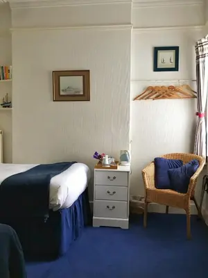 a bedroom with a bed and a chair at The Moorings B&B in Southend-on-Sea