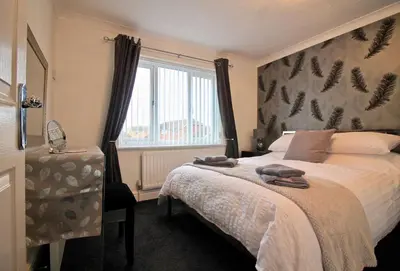 a bedroom with a large bed and a window at Seascape in Clacton-on-Sea