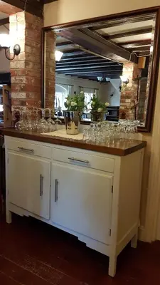 a counter with wine glasses on it with a mirror at The Pelican Guesthouse in Ashwellthorpe