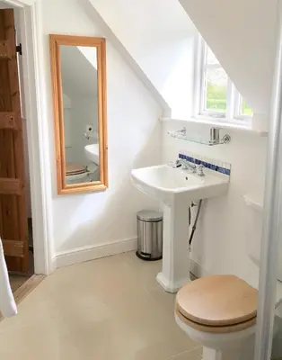 a bathroom with a sink and a mirror at Partridge Lodge Self Catering houses in Woodbridge