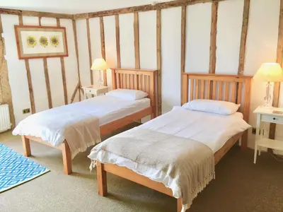 two beds in a room with two tables and two lamps at Partridge Lodge Self Catering houses in Woodbridge