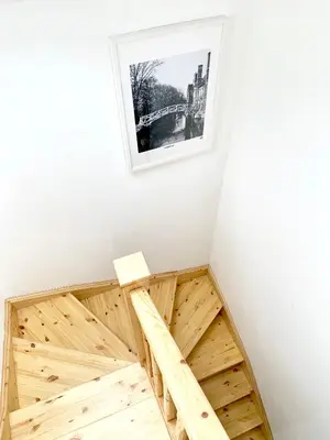 a room with a wooden bed with a picture on the wall at The Birches in Cambridge