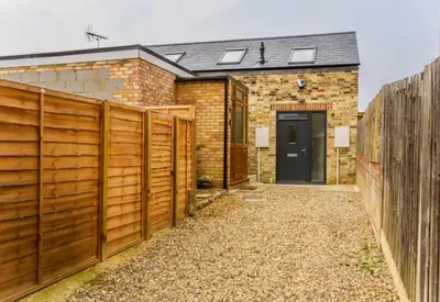 a wooden fence in front of a house at The Birches in Cambridge