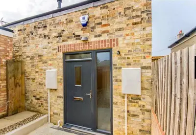 a brick building with a blue door on it at The Birches in Cambridge