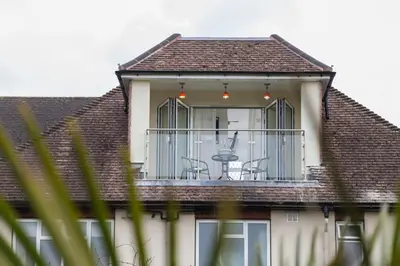 a house with a balcony with chairs on it at Elmcroft Guest House in Epping