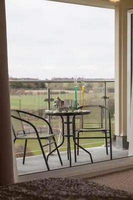a table and chairs on a balcony with a view at Elmcroft Guest House in Epping