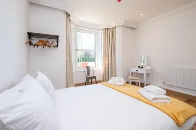 a white bedroom with a large bed and a window at Birch - Three Tuns Apartments - Pettistree, Wickham Market - by Aldeburgh Coastal Cottages in Pettistree