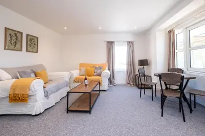 a living room with a couch and a table at Elm - Three Tuns Apartments, Pettistree, Wickham Market - by Aldeburgh Coastal Cottages in Pettistree