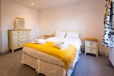 a bedroom with a bed with towels on it at Elm - Three Tuns Apartments, Pettistree, Wickham Market - by Aldeburgh Coastal Cottages in Pettistree