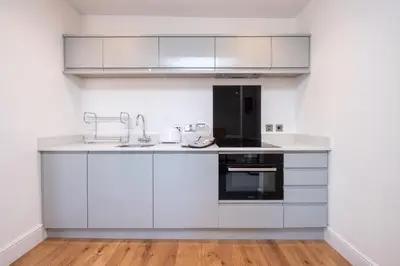 a kitchen with white cabinets and a sink at Elm - Three Tuns Apartments, Pettistree, Wickham Market - by Aldeburgh Coastal Cottages in Pettistree