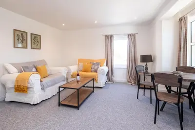 a living room with a couch and a table at Elm - Three Tuns Apartments, Pettistree, Wickham Market - by Aldeburgh Coastal Cottages in Pettistree