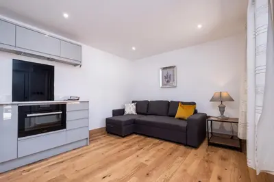 a living room with a couch and a tv at Weeping Willow - Three Tuns Apartments, Pettistree, Wickham Market - by Aldeburgh Coastal Cottages in Pettistree