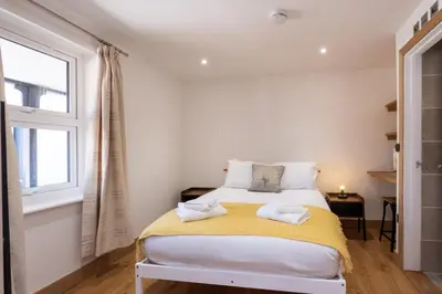 a bedroom with a bed with towels on it at Weeping Willow - Three Tuns Apartments, Pettistree, Wickham Market - by Aldeburgh Coastal Cottages in Pettistree