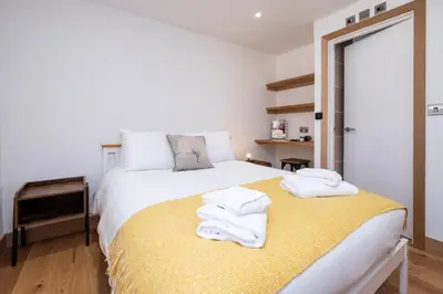 a bedroom with a bed with towels on it at Weeping Willow - Three Tuns Apartments, Pettistree, Wickham Market - by Aldeburgh Coastal Cottages in Pettistree