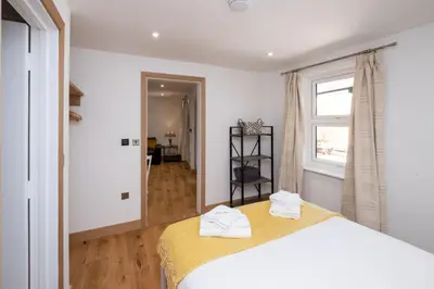 a bedroom with a bed with two towels on it at Weeping Willow - Three Tuns Apartments, Pettistree, Wickham Market - by Aldeburgh Coastal Cottages in Pettistree