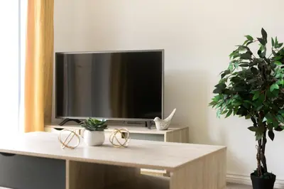 a tv sitting on top of a table in a living room at Hertford Serviced Apartments in Hertford