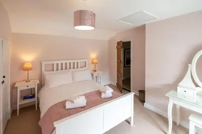 a bedroom with a white bed and two night stands at Little Tern Cottage in Aldeburgh