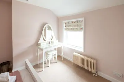 a bedroom with a dressing table and a mirror at Little Tern Cottage in Aldeburgh