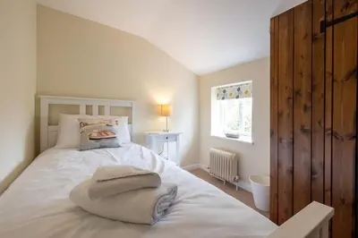 a bedroom with a bed with towels on it at Little Tern Cottage in Aldeburgh
