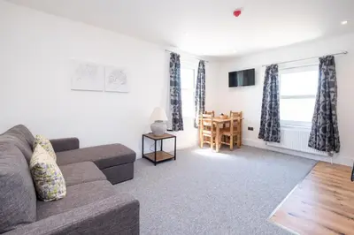 a living room with a couch and a table at Rowan - Three Tuns Apartments , Wickham Market - by Aldeburgh Coastal Cottages in Pettistree