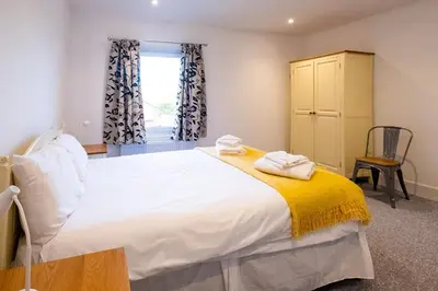 a bedroom with a large white bed and a window at Rowan - Three Tuns Apartments , Wickham Market - by Aldeburgh Coastal Cottages in Pettistree