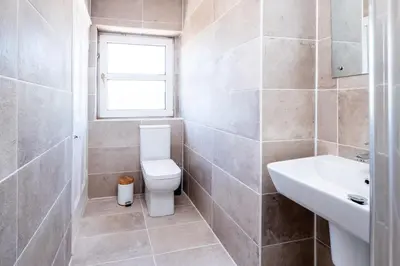 a bathroom with a toilet and a sink and a window at Rowan - Three Tuns Apartments , Wickham Market - by Aldeburgh Coastal Cottages in Pettistree