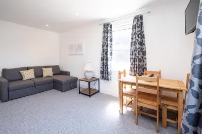 a living room with a couch and a table at Rowan - Three Tuns Apartments , Wickham Market - by Aldeburgh Coastal Cottages in Pettistree