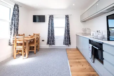 a kitchen with a table and a dining room at Rowan - Three Tuns Apartments , Wickham Market - by Aldeburgh Coastal Cottages in Pettistree