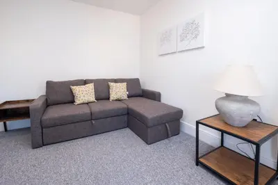 a living room with a couch and a table at Rowan - Three Tuns Apartments , Wickham Market - by Aldeburgh Coastal Cottages in Pettistree