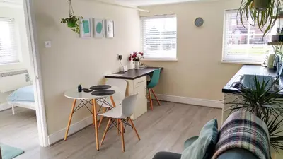 a kitchen and living room with a table and chairs at The Annexe in Hawkedon