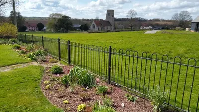 a fence with a garden in a field at The Annexe in Hawkedon