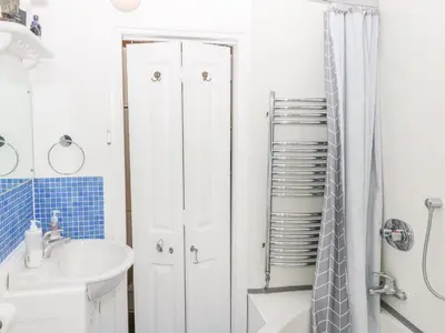 a white bathroom with a shower and a sink at 3 Station Cottages in Wymondham