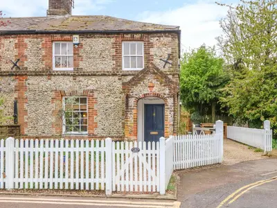 a white picket fence in front of a brick house at 3 Station Cottages in Wymondham