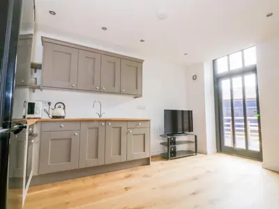 a kitchen with wooden floors and a large window at Grange Barn in Hessett