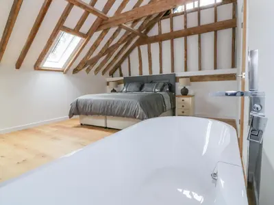 a bedroom with a bed in a attic at Grange Barn in Hessett