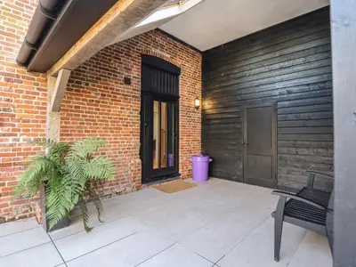 a patio with a bench and a brick wall at Grange Barn in Hessett