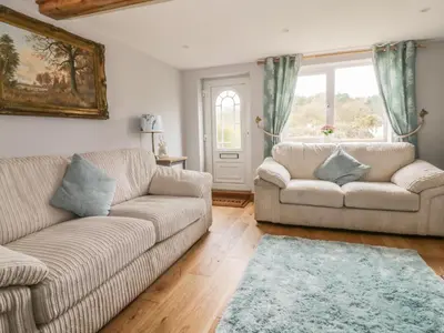 a living room with two couches and a window at 2 Hillside Cottages in Ipswich
