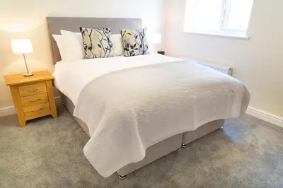 a bedroom with a bed with a white comforter at Citystay Living - Franklin House in Cambridge