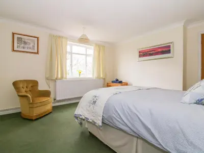 a bedroom with a bed and a chair and a window at The Bothy in Eye