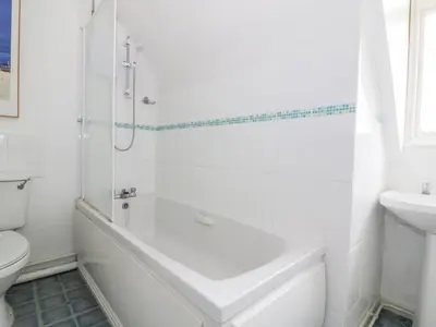 a bathroom with a tub and a toilet and a sink at The Bothy in Eye