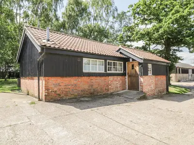 a small brick house with a door in a driveway at The Bull Pen in Eye