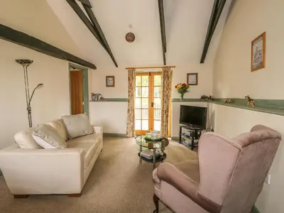 a living room with a couch and two chairs and a tv at The Bull Pen in Eye