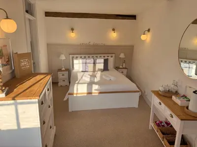 a bedroom with a bed and a vanity and a mirror at Black Buoy Inn in Wivenhoe
