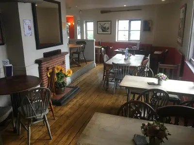 a restaurant with tables and chairs and a fireplace at Black Buoy Inn in Wivenhoe