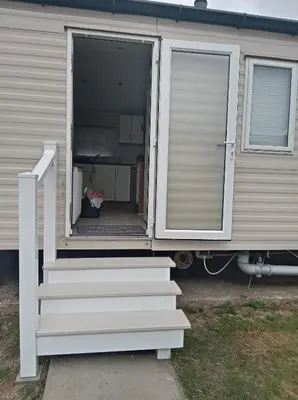 an open door of a mobile home with stairs at Caledonian Caravan in Jaywick Sands