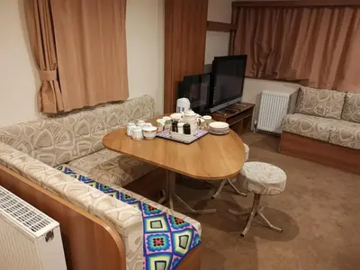 a living room with a couch and a table at Caledonian Caravan in Jaywick Sands