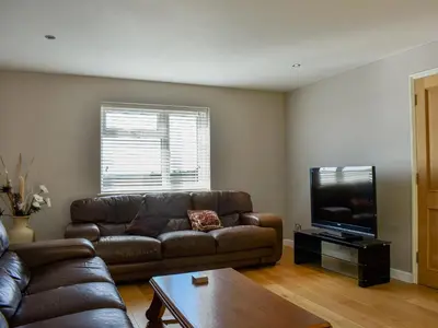 a living room with a couch and a flat screen tv at Hill Farm Cottage in Stretham