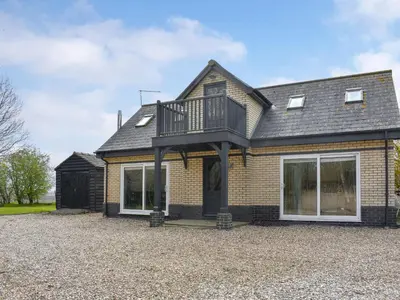 a house with a balcony on top of it at Hill Farm Cottage in Stretham